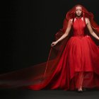 Surreal portrait of woman in oversized red gown with hoop, second woman's head emerges.