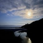 Nocturnal landscape with full moon, water reflection, hills, trees, and sailing ship