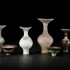 Assorted porcelain vases and bowls on black background