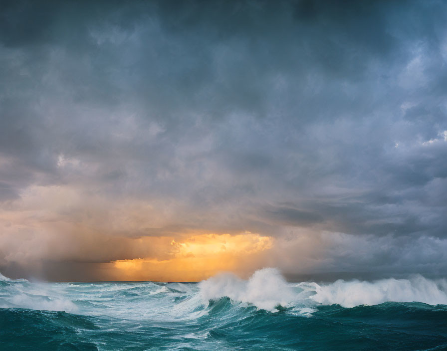 Stormy sky over churning ocean waves with golden sunlight glimpse