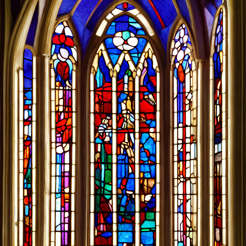 Colorful stained glass window in red, blue, and yellow with gothic stone arches