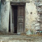 Quaint doorway with pink roses, cobblestone steps & cozy interior glimpse