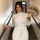 Stylish woman in white dress with cutouts holding fan on escalator