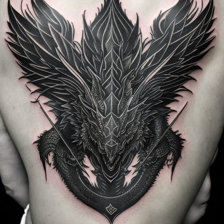 Intricate black ink dragon tattoo on chest with scales and wings.