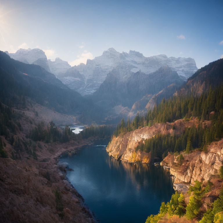 Mountain landscape with winding river, forested hills, and snowy peaks