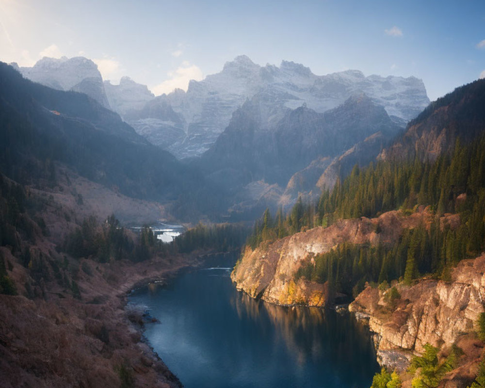 Mountain landscape with winding river, forested hills, and snowy peaks