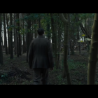 Uniformed officer in dense forest with sunlight filtering through trees