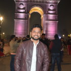 Shiny jacket-wearing youth under night archway with bokeh lights