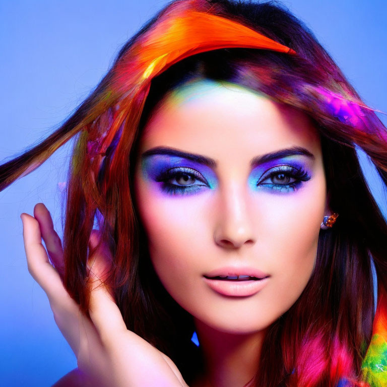 Colorful woman with rainbow hair and blue eyeshadow on blue background