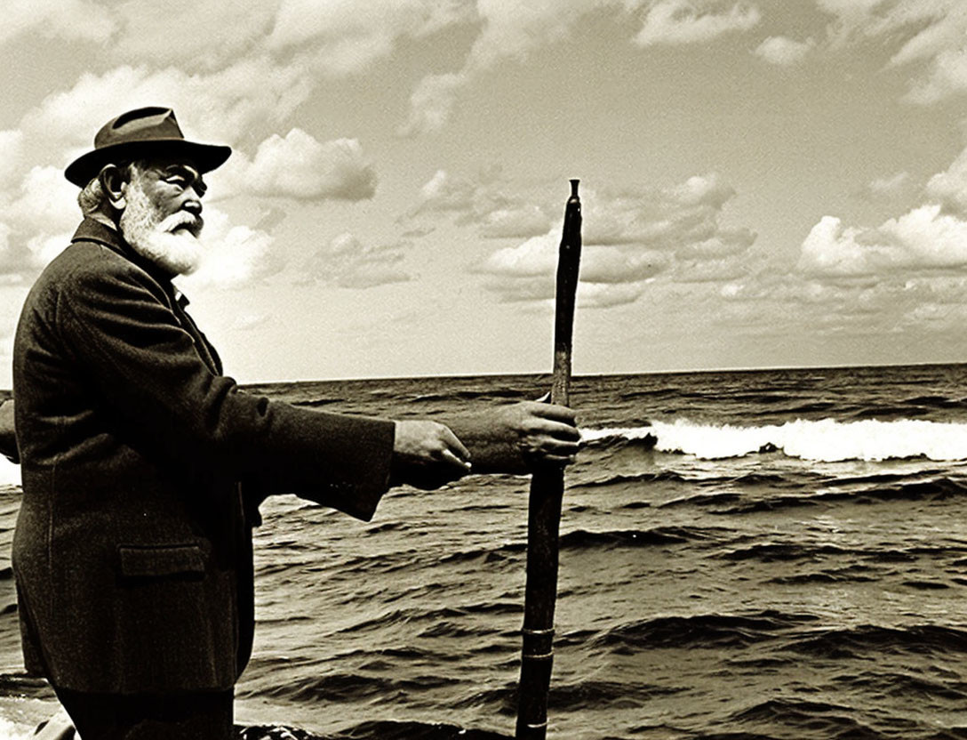 Elderly man with beard and staff by ocean horizon