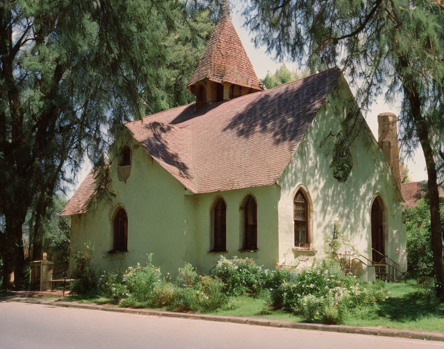 Old Church with Sloped Roof Surrounded by Trees Under Blue Sky