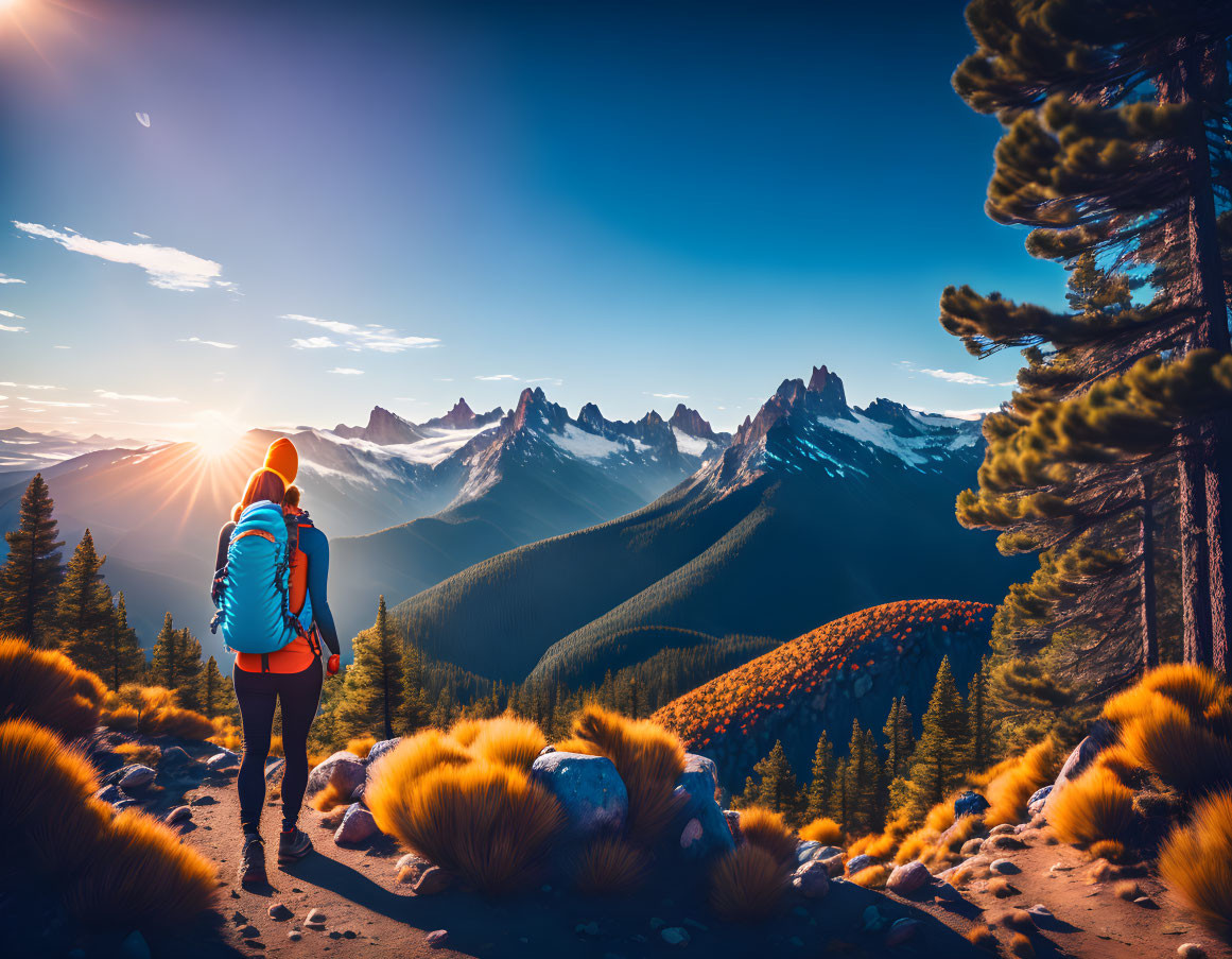 Hiker admiring mountain range at sunrise with warm sun glow