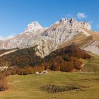 Snow-capped peaks and autumnal forest in serene mountain landscape