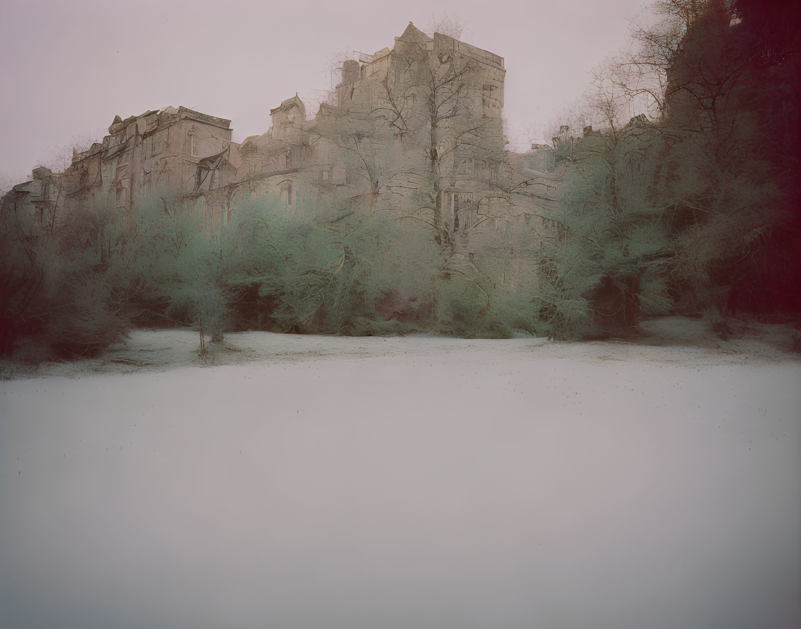 Eerie misty landscape with imposing building and frost-covered trees