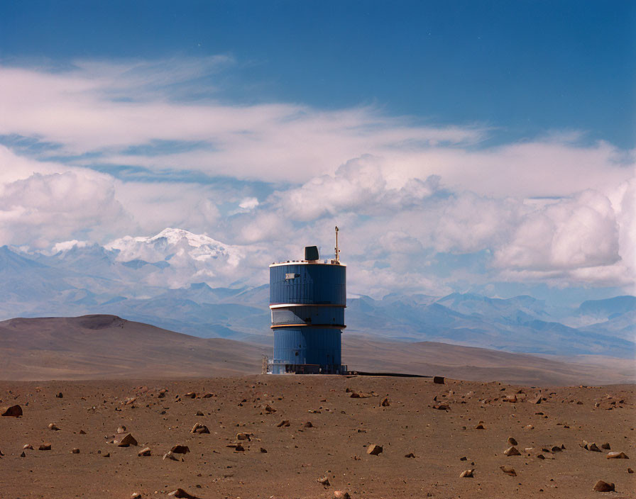 Astronomical observatory under vast blue sky and snowy mountains