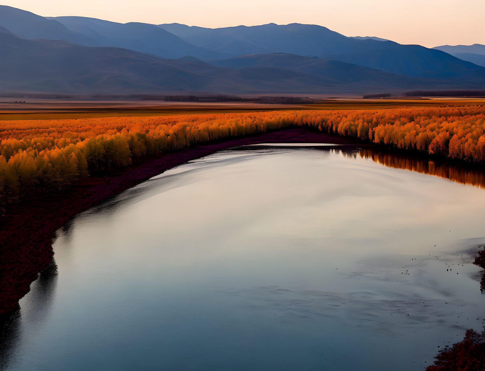 Tranquil river in autumn landscape with golden trees and mountains