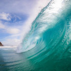 Translucent Turquoise Ocean Wave Against Clear Sky