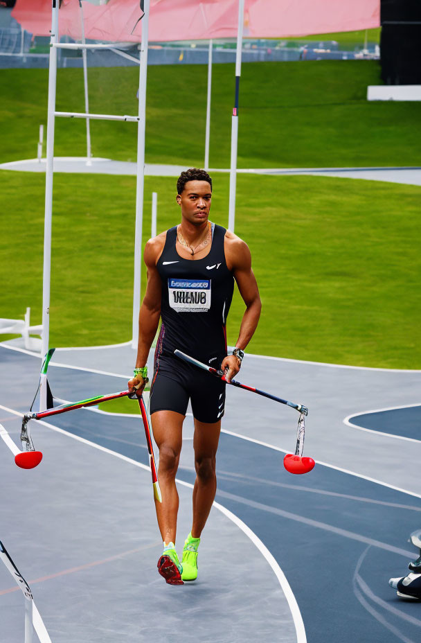 Athlete in Black Nike Outfit Walking on Track with Red Javelins