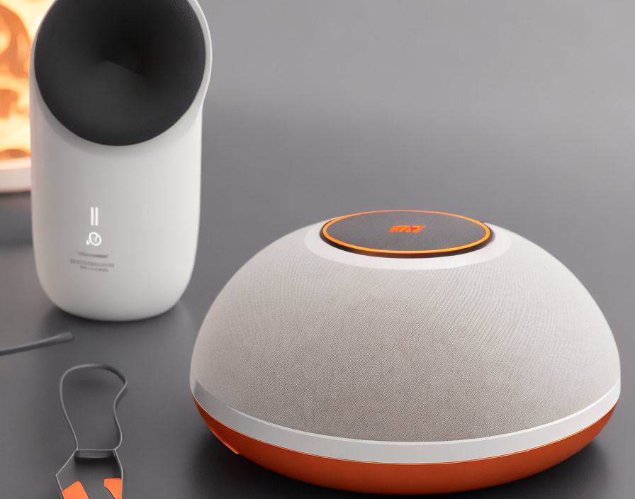 Sleek wireless speaker on table with fabric cover and orange accents