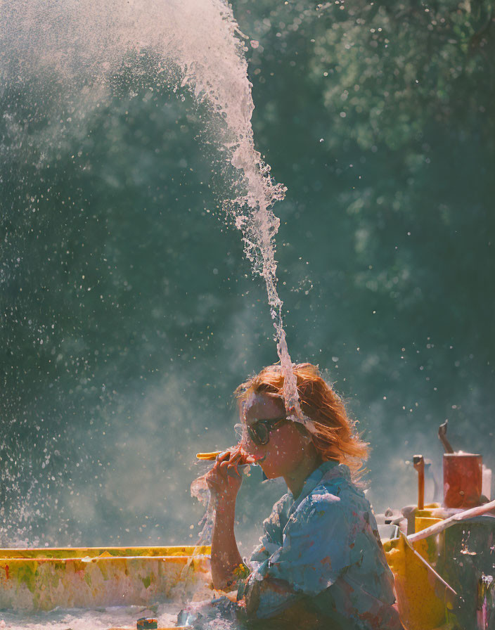 Woman in sunglasses sitting behind water jet with sunlight and cigarette.