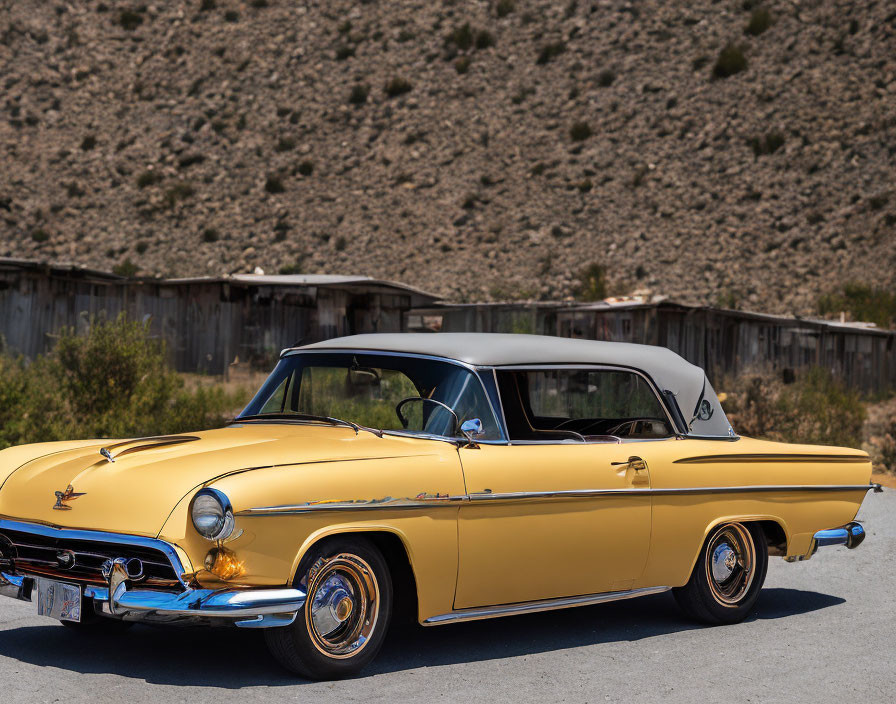 Yellow Classic Convertible Car with Closed B&W Top on Road in Dry Hill Terrain