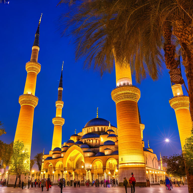 Twilight scene of illuminated mosque with tall minarets, people walking, and palm trees.