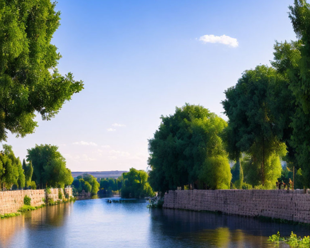 Tranquil river scene with lush trees, blue sky, and stone embankment