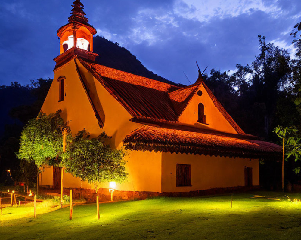 Rustic church with illuminated bell tower at twilight