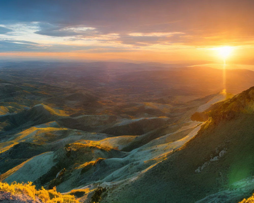 Mountainous Landscape at Sunset with Warm Glow and Rolling Shadows