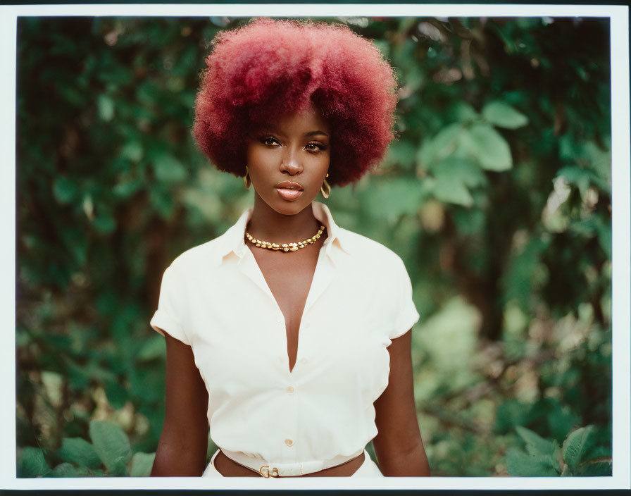 Red Afro-Haired Woman in Yellow Shirt on Green Leafy Background