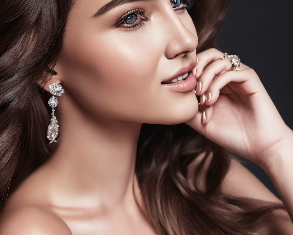 Wavy-haired woman with elegant earrings and makeup smiling