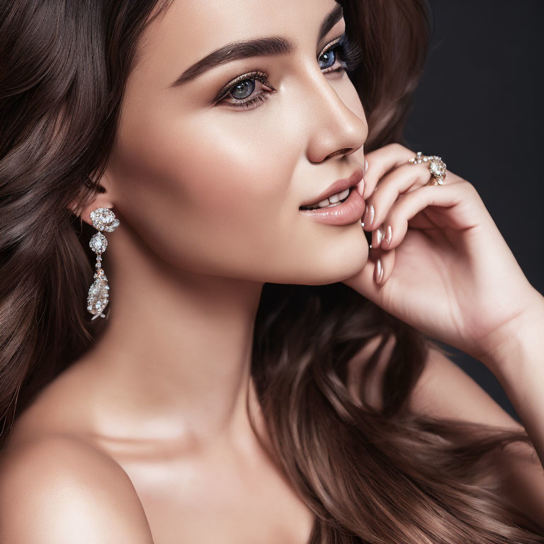 Wavy-haired woman with elegant earrings and makeup smiling