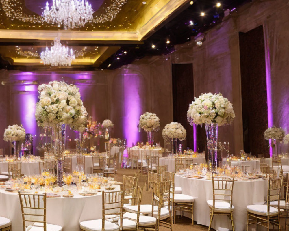 Luxurious Event Decor: Tall Floral Centerpieces, Crystal Chandeliers, Golden Chairs, Purple Lighting