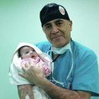 Healthcare Professional in Scrubs Holding Newborn Baby with Stethoscope