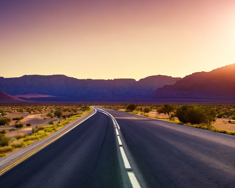 Scenic road with mountains under gradient sunset sky