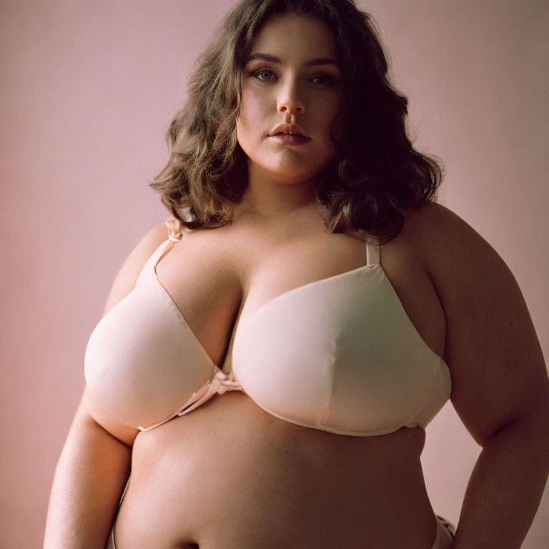 Plus-Size Woman in Beige Bra on Pink Background