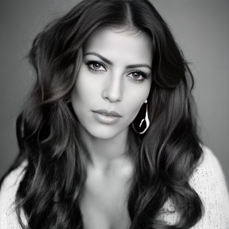 Monochrome portrait of woman with long wavy hair and teardrop earrings