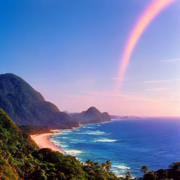 Scenic coastal landscape with rainbow over lush hills