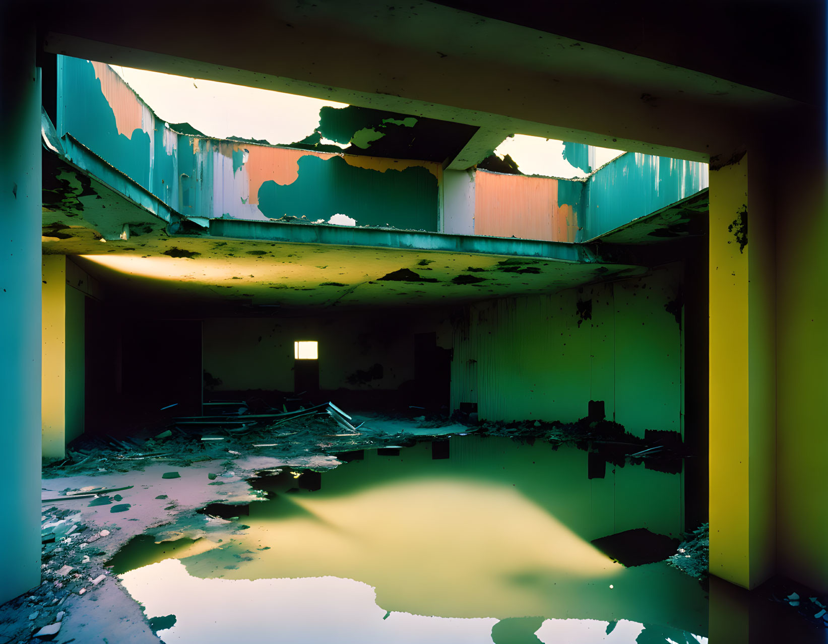 Peeling paint in flooded abandoned building with yellow and blue walls.