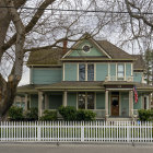 Charming cottage with blooming flowers, trees, and picket fence in sunlight