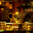 Intricate Gold Teapot Set with Ornate Cups and Dramatic Lighting