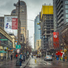 City winter scene: snowfall, pedestrians, vintage cars, illuminated buildings at dusk