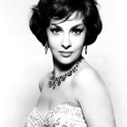 Monochrome portrait of a woman with voluminous hair and bejeweled necklace in floral embroidered dress