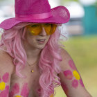 Colorful Woman in Pink Hat Against Foliage Backdrop