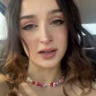 Portrait of young woman with brown curly hair and colorful necklace