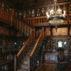 Elegant woman in vintage library with bookshelves and chandelier