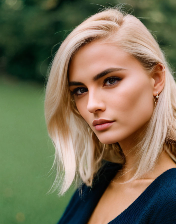 Blonde woman portrait in blue top with subtle smile