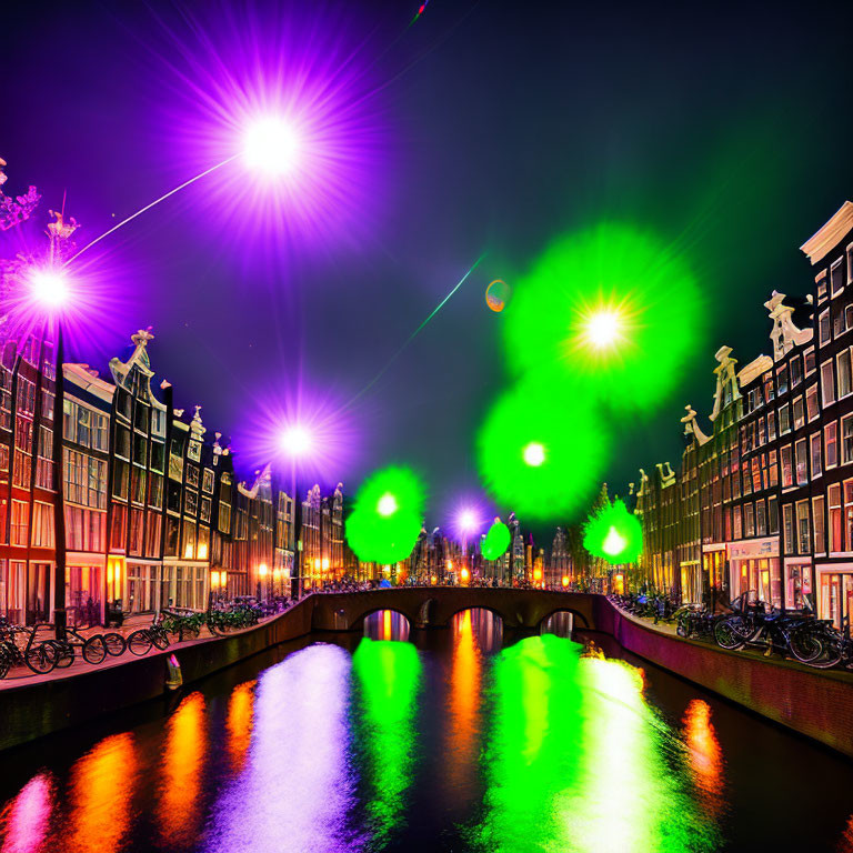 Amsterdam canal at night with illuminated buildings and bikes