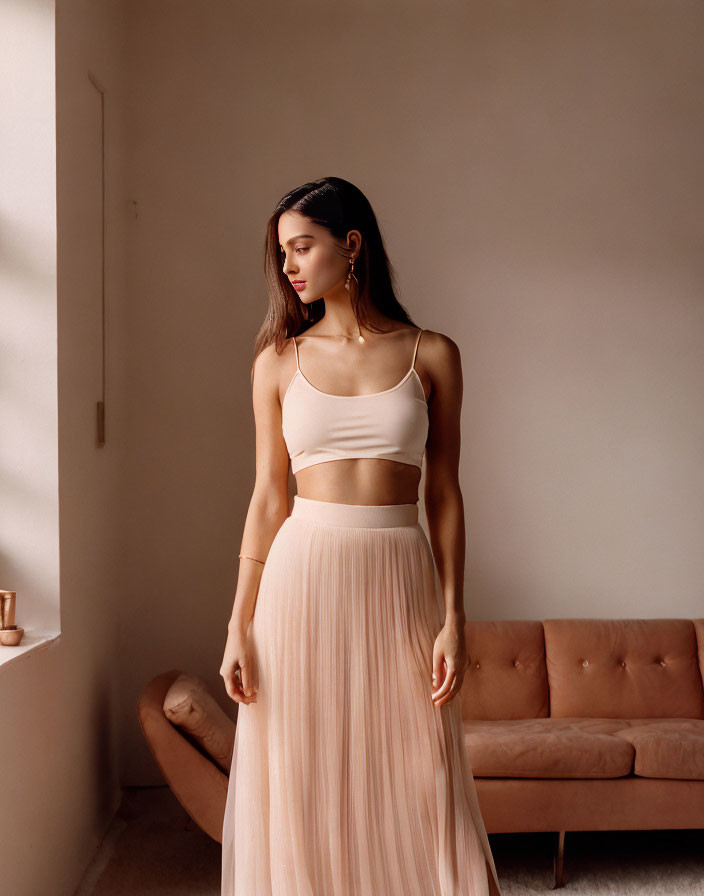 Woman in White Crop Top and Pastel Skirt Poses in Sunlit Room