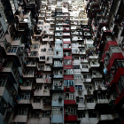 Tall grey and red residential buildings with multiple windows and air-conditioning units